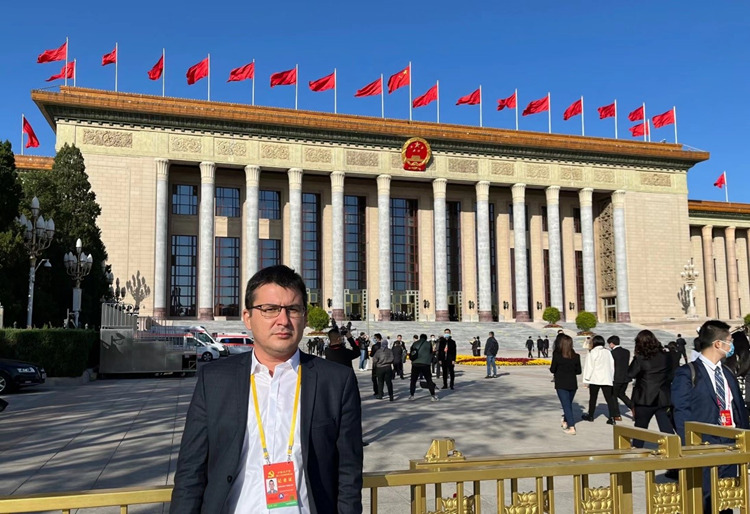 乌兹别克斯坦《人民言论报》副总编辑鲁斯兰·肯扎耶夫参加报道中国共产党第二十次全国代表大会。进入会场前，肯扎耶夫在人民大会堂前留影。受访者供图